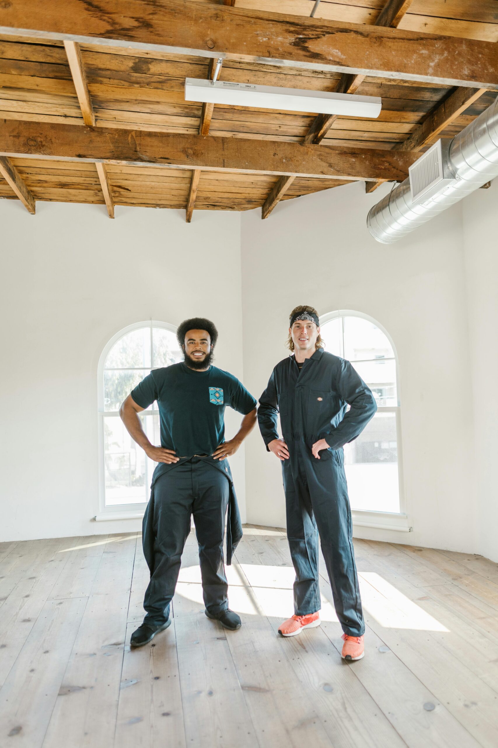 Two professional movers in an empty apartment, ready to assist with moving services.